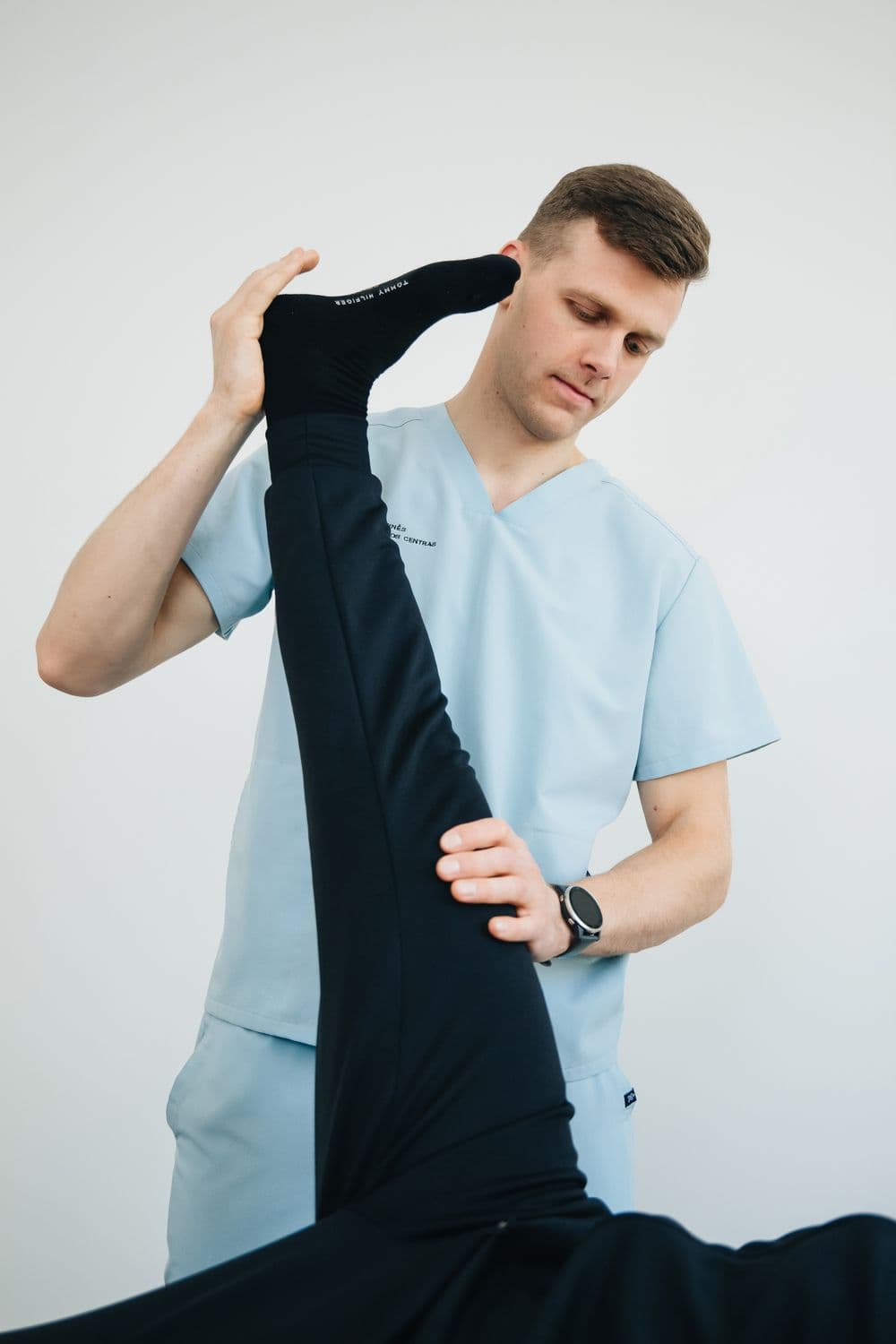A physiotherapist supporting a patient during a guided leg exercise